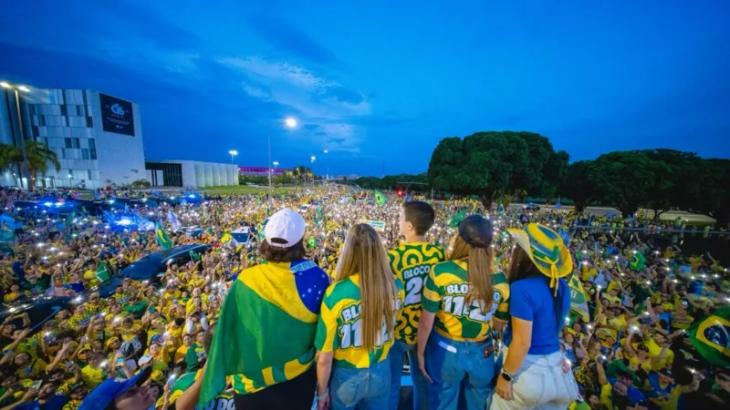 Sob luzes, apoiadores de Flávio e Celina cantam o Hino Nacional em ato no DF