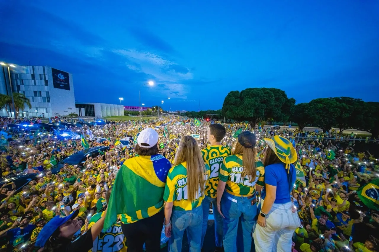 Sob luzes, apoiadores de Flávio e Celina cantam o Hino Nacional em ato no DF